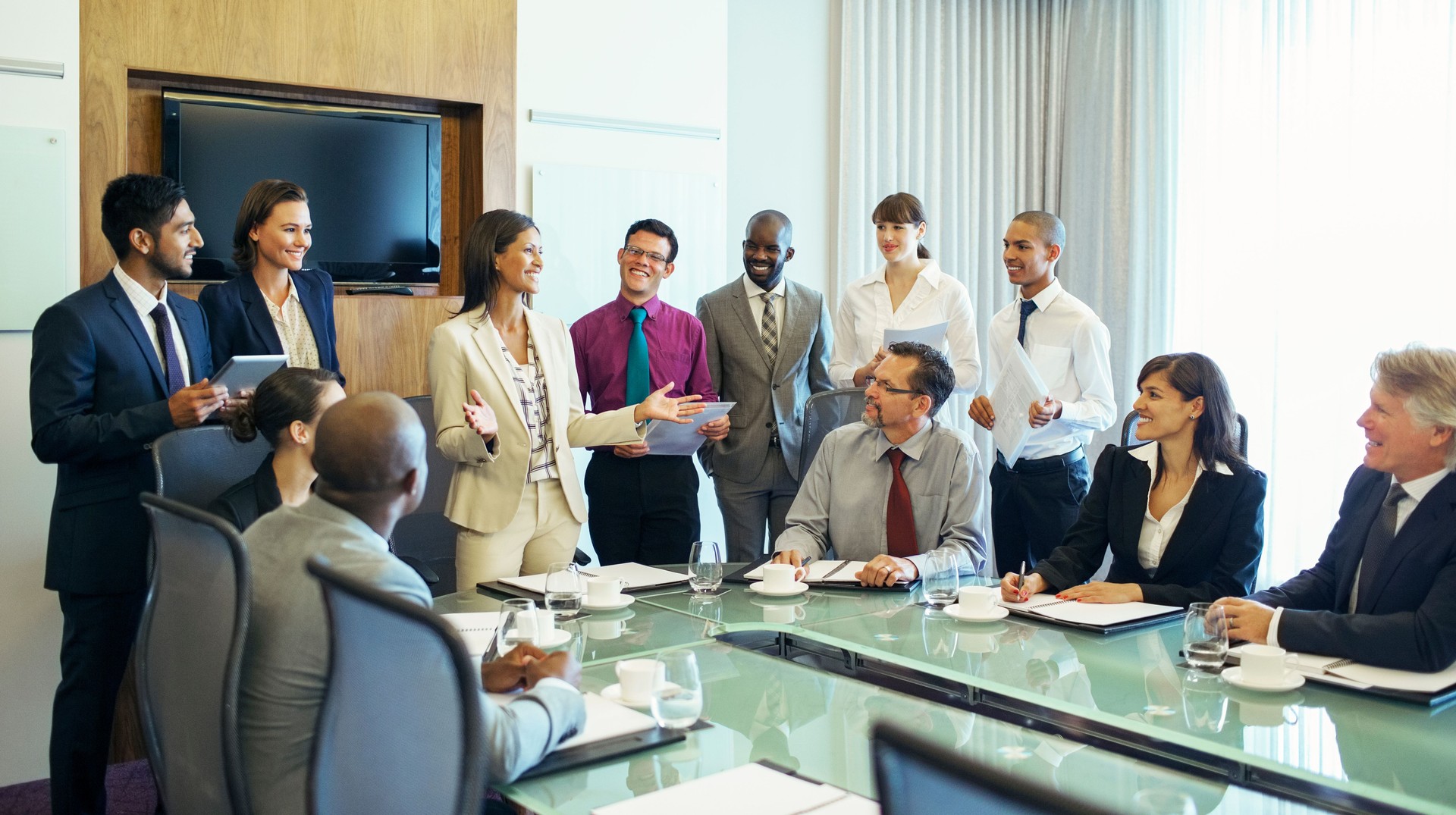 Businesswoman standing at head of conference table and talking